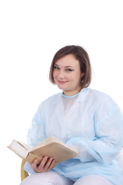 Pretty female doctor reading book — Stock Photo, Image