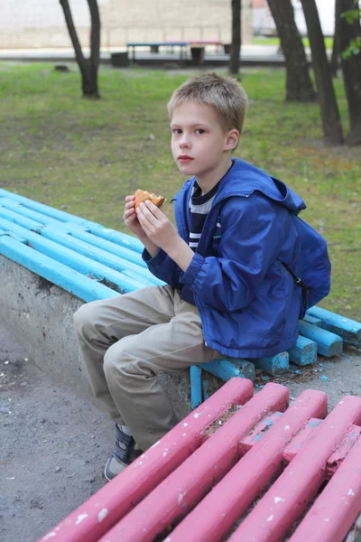 Malý chlapec jíst hamburger — Stock fotografie