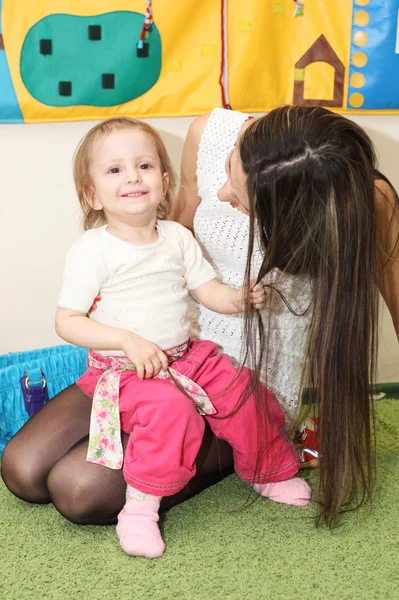 Little girl holding mother's hair — Stock Photo, Image