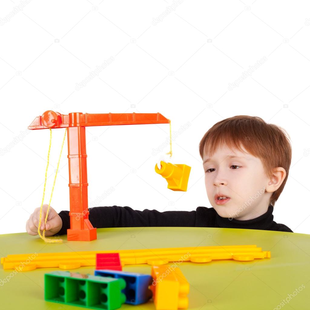 little boy playing with toy crane