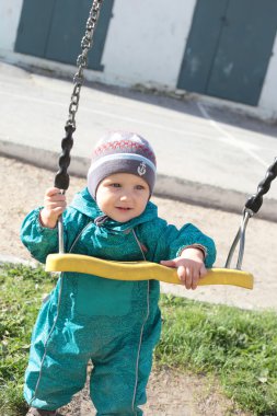 Salıncak ile oynayan sevimli küçük çocuk