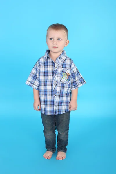 Kleine jongen op de blauwe achtergrond — Stockfoto