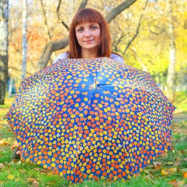 Frau mit Regenschirm im Herbstpark — Stockfoto