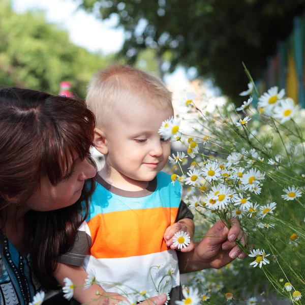 Маленький ребенок нюхает цветы — стоковое фото