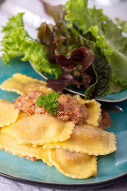 Krema soslu ravioli ve salata.