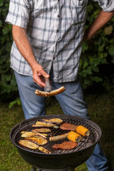 Mężczyzna Trzymający Kiełbasę Grillu — Zdjęcie stockowe