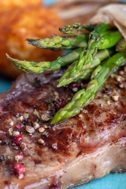 Bifteğin üstünde yeşil kuşkonmaz
