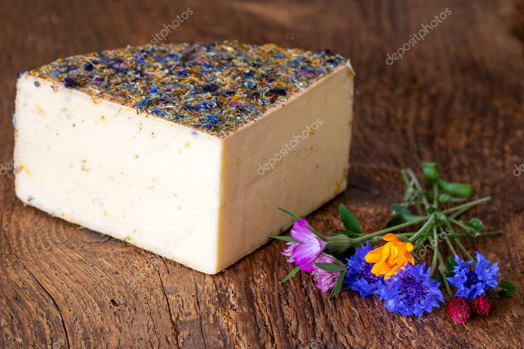 mountain cheese with flowers on wood