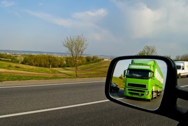 Green, a moving truck in the reflection of the mirror associated clipart