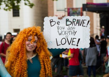 BOISE, IDAHO/USA - JUNE 20, 2016: Person dressed up as Merida from Brave showing that people are worthy of love during Boise Pridefest clipart