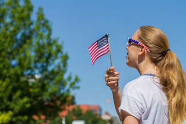 Boise, Idaho - 4 Temmuz 2016: Boise, Idaho'da 4 Temmuz geçit töreni sırasında bayrağını kaldıran kız