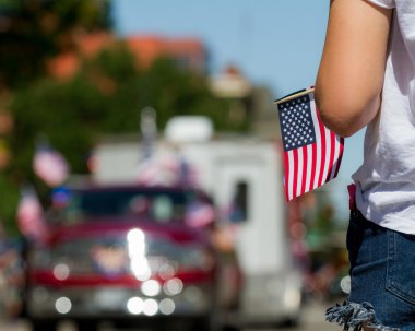 Boise, Idaho - 4 Temmuz 2016: Arka planda geçit töreni yle amerikan bayrağı tutan kız