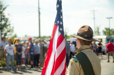 MERIDIAN, IDAHO/USA - JULY 30, 2016: Member from the Boy scouts waits to walk the flag to the gathering place for the pro police rally in Meridian, Idaho clipart