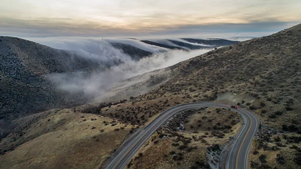 Carro viajando em uma estrada durante o nevoeiro — Fotografia de Stock