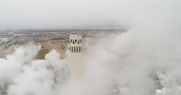 Drone flying above a factory with its smoke — Stock Video