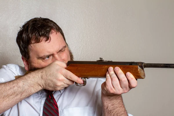 Homem apontando uma arma enquanto no trabalho — Fotografia de Stock