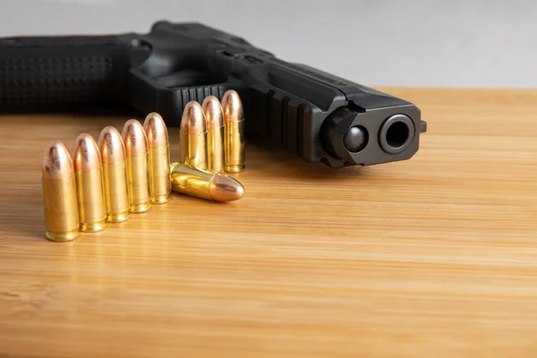 Pistola deitada com munição ao lado de bater — Fotografia de Stock