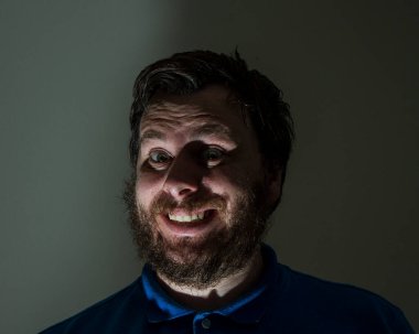 Işığı sönük bir adama garip bir gülümseme.