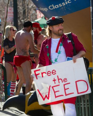 BOISE, IDAHO/USA FEBRUARY 13, 2016: During the Cupid Underwear Run for neurofibromatosis a man shows his pro marijuana sign in Boise, Idaho clipart