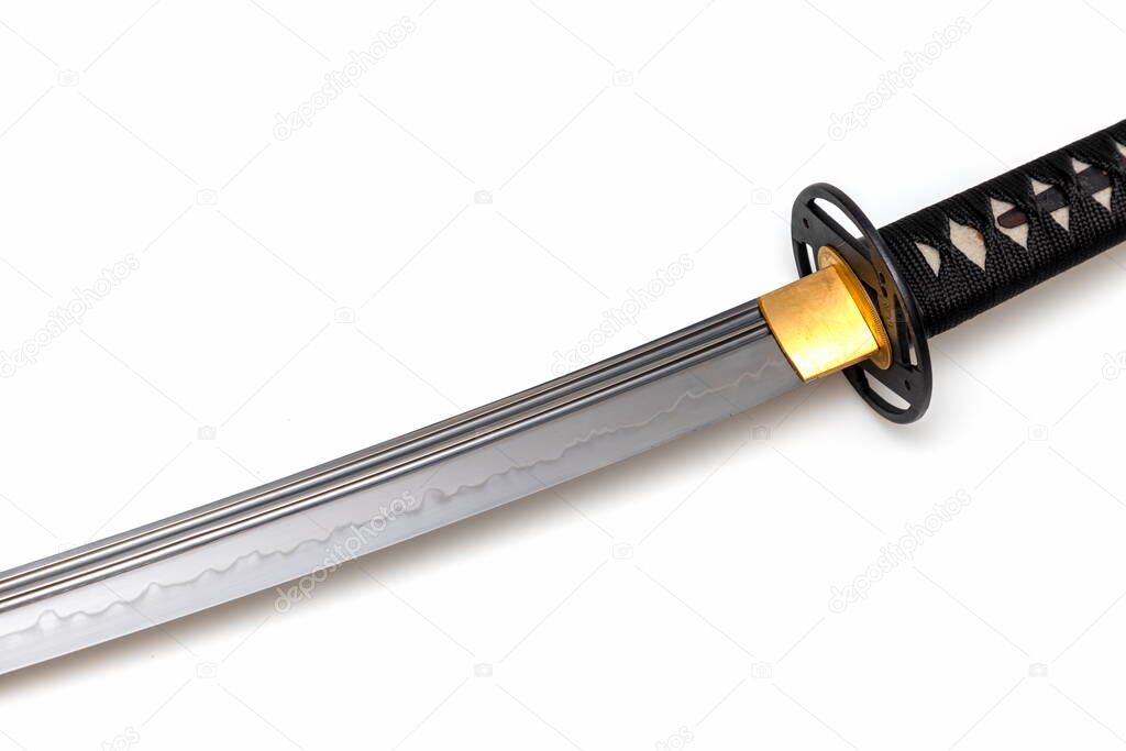 Japanese sword blade (made in China) on white background. Soft focus.  The wavy pattern on the blade edge is a line of hardness that a blacksmith makes so that the blade doesn't break.