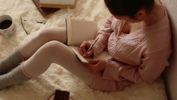 Красивая женщина пишет в своем дневнике — стоковое видео