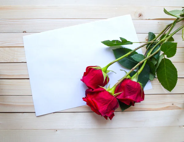 Red roses on a wooden table — Stock Photo, Image