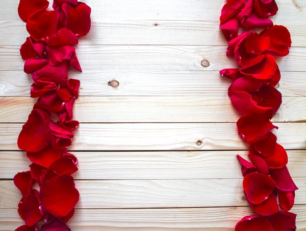 Pétalos de rosa sobre una mesa de madera — Foto de Stock