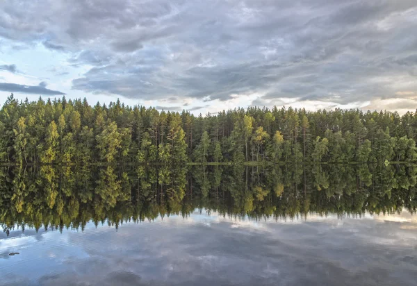 Foresta e nuvole si riflettono nel fiume — Foto Stock