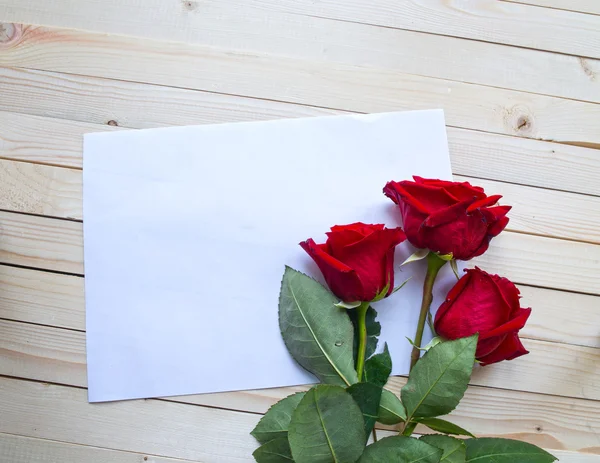 木製のテーブルの上に赤いバラ — ストック写真