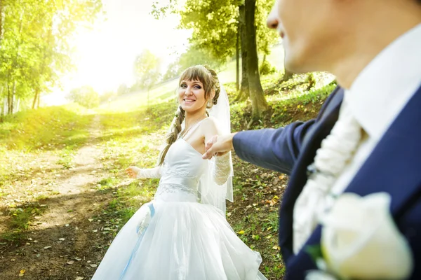 The bride is leading groom on a road — Stock Photo, Image