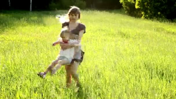 Mãe feliz transforma uma criança no prado — Vídeo de Stock