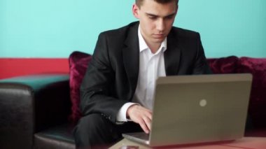 Adam bir dizüstü bilgisayarda yazarak