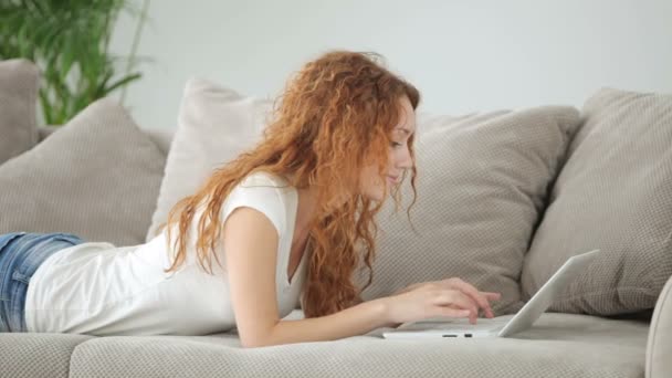 Vrouw liggend op de Bank met behulp van laptop — Stockvideo