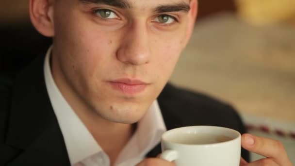 Человек пьет кофе и улыбается — стоковое видео