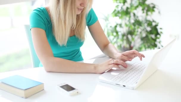 Mulher sentada à mesa usando laptop — Vídeo de Stock