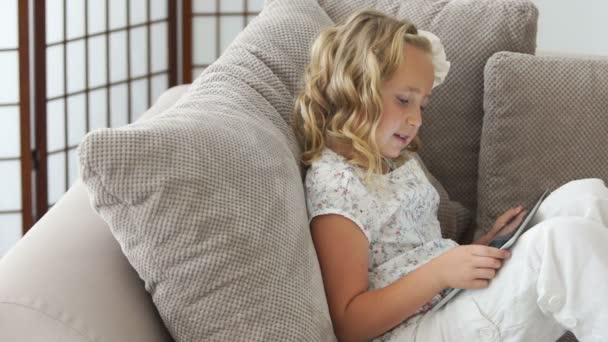 Menina no sofá jogando no PC tablet — Vídeo de Stock