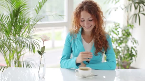 Woman sitting at table drinking coffee — Stock Video