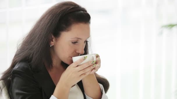 Hübsche junge Frau trinkt Kaffee — Stockvideo