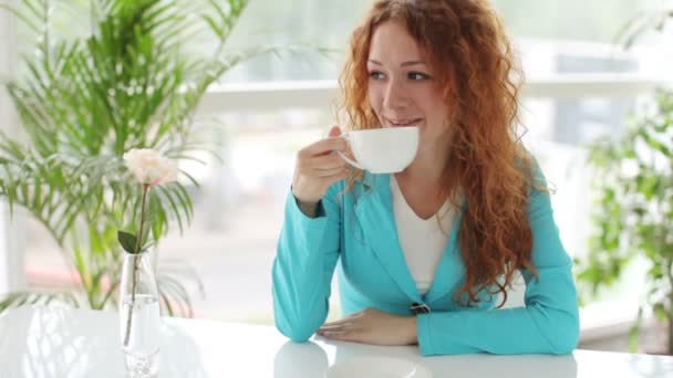Menina sentada à mesa beber café — Vídeo de Stock