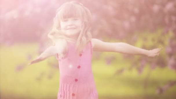 Niña girando en el jardín — Vídeo de stock