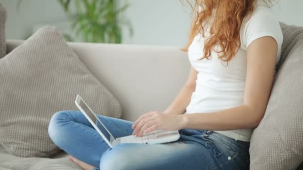 노트북을 사용하여 소파에 앉아 있는 여자 — 비디오