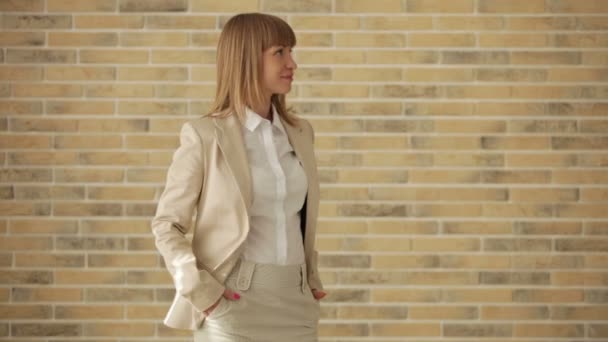 Woman posing in front of brick wall — Stock Video