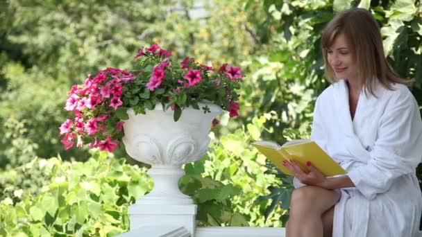 Een vrouw die een boek leest. — Stockvideo