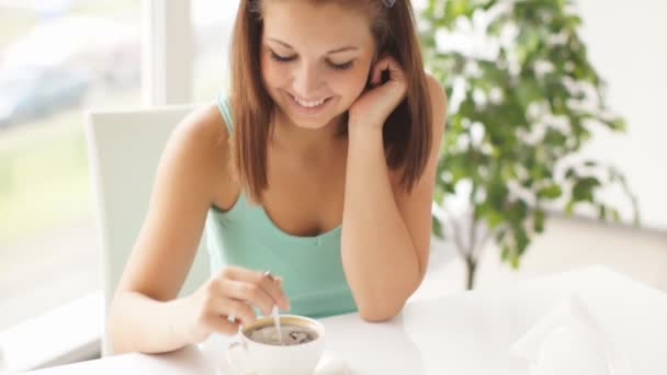 コーヒーを攪拌のテーブルに座っている女性 — ストック動画