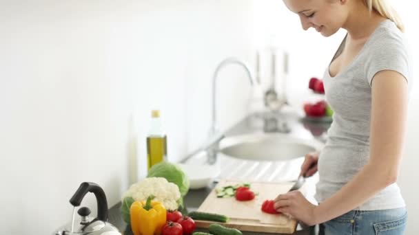 Hübsche junge Frau schneidet Tomaten — Stockvideo