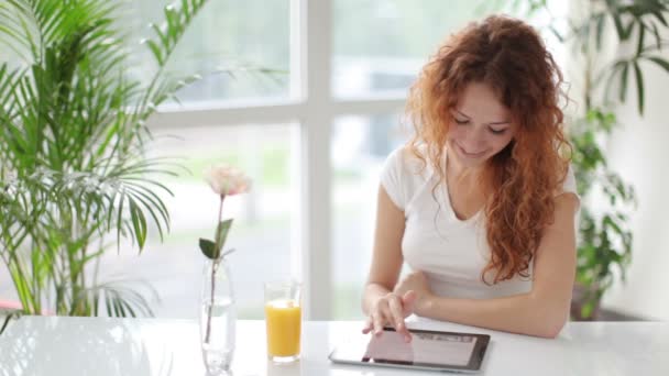 Frau sitzt mit Touchpad am Tisch — Stockvideo