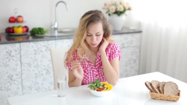 Chica sentada en la mesa en la cocina — Vídeos de Stock