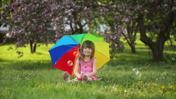 Schattig klein meisje, zittend op het gras — Stockvideo
