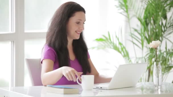 Frau sitzt am Tisch und arbeitet am Laptop — Stockvideo