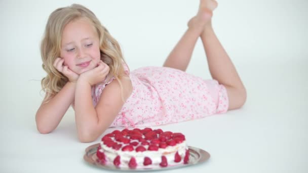 Chica mintiendo y admirado pastel de fresa — Vídeo de stock